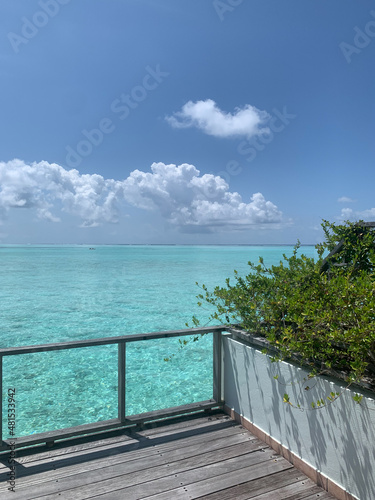 A day in the Maldives, a villa with green shrubs in flower beds over the water near the coast of the Indian Ocean