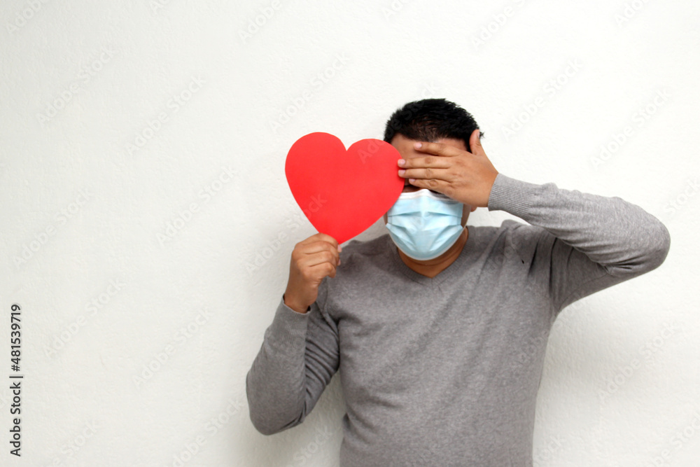 Latino adult man with face mask as protection in the new normality due to the Covid-19 pandemic shows a red heart to celebrate Valentine's Day of Love and Friendship
Latino adult man with face mask as protection in the new normality due to the Covid-19 pandemic shows a red heart to celebrate Valentine's Day of Love and Friendship