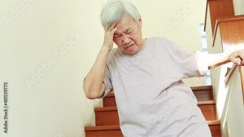 Asian senior woman suffering from dizziness,sensation of spinning around,losing her balance,old elderly touching her temple with eyes closed,vertigo while downstairs,dizzy,tendency to fall or stagger