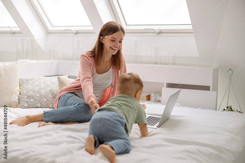 Baby crawling on the bed to mom laptop Baby crawling on the bed to mom laptop