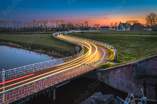 Curve light trails on country road in the landscape of the province of Groningen, The Netherlands