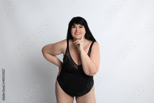 Beautiful overweight woman in black underwear on light background. Plus-size model © New Africa
