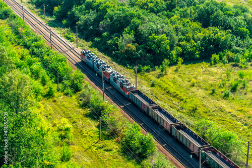 Freight train among the trees shot from the air.