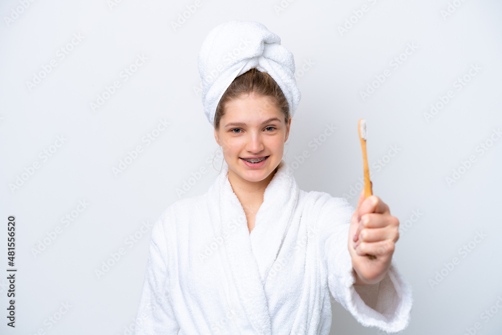 Teenager Russian girl brushing teeth isolated on white background with happy expression Teenager Russian girl brushing teeth isolated on white background with happy expression