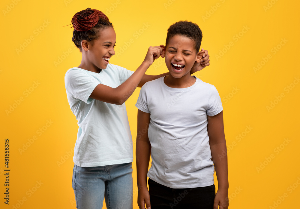 Naughty older sister pulling her brother ears Naughty older sister pulling her brother ears