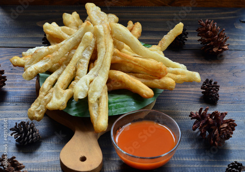 A plate of Cakwe or Cakue with chilli sauce at wooden table. Cakwe is a popular traditional snack from Chinese and indonesia photo