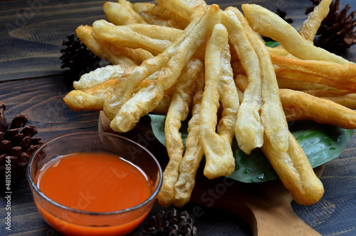 A plate of Cakwe or Cakue with chilli sauce at wooden table. Cakwe is a popular traditional snack from Chinese and indonesia photo