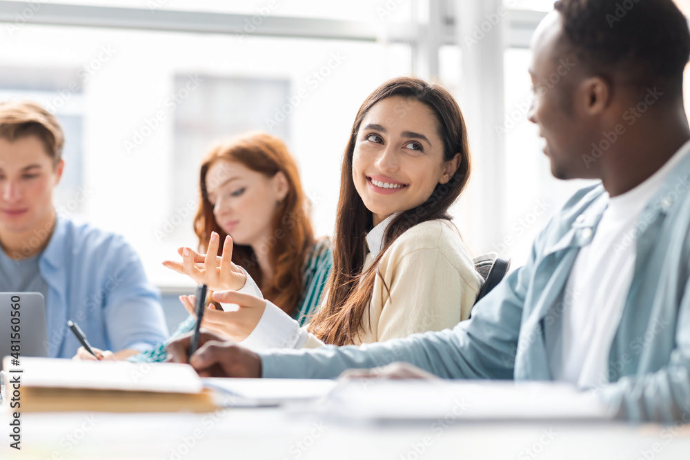 International group of people sitting at desk and talking International group of people sitting at desk and talking