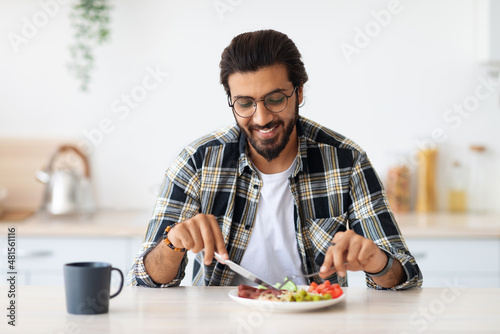Positive arab guy having healthy breakfast at home
