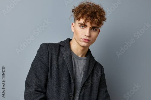 handsome young man in a gray sweatshirt coat fashion studio isolated background