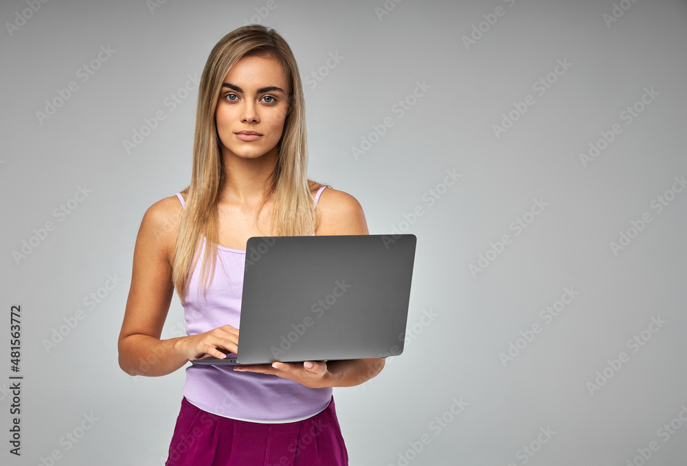 Portrait of blonde woman with laptop isolated on grey background Portrait of blonde woman with laptop isolated on grey background