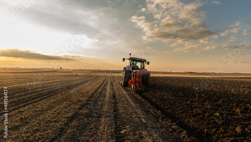 Tractor on the field during sunset.