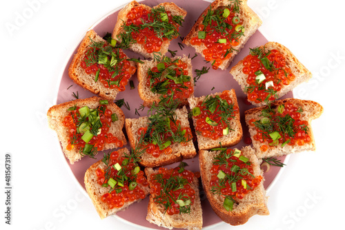 Tartlets with red caviar on bread. Salmon caviar close-up. sliced white fish.Red fish.on a plate.Delicious food.The texture of caviar. Seafood appetizer.on an isolated white background. space for text