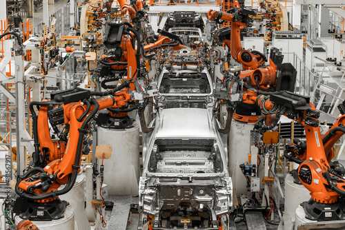 Photo of automobile production line. Modern car assembly plant. Modern and high-tech automotive industry