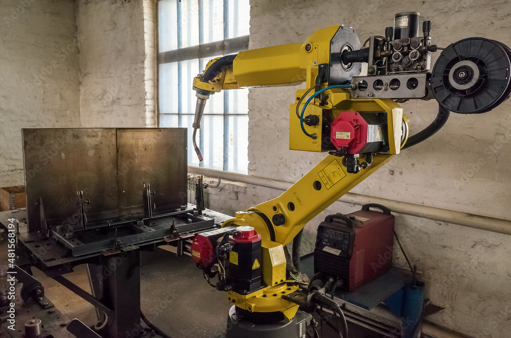 A welding robot in a production room of a mechanical plant. The picture was taken in Russia