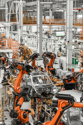 Vertical photo of automobile production line. Modern car assembly plant. Auto industry. Interior of a high-tech factory, modern production