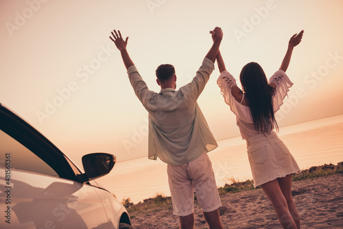 Back rear view photo of young couple enjoy date honeymoon vacation seaside car freedom hold hands summer outdoors