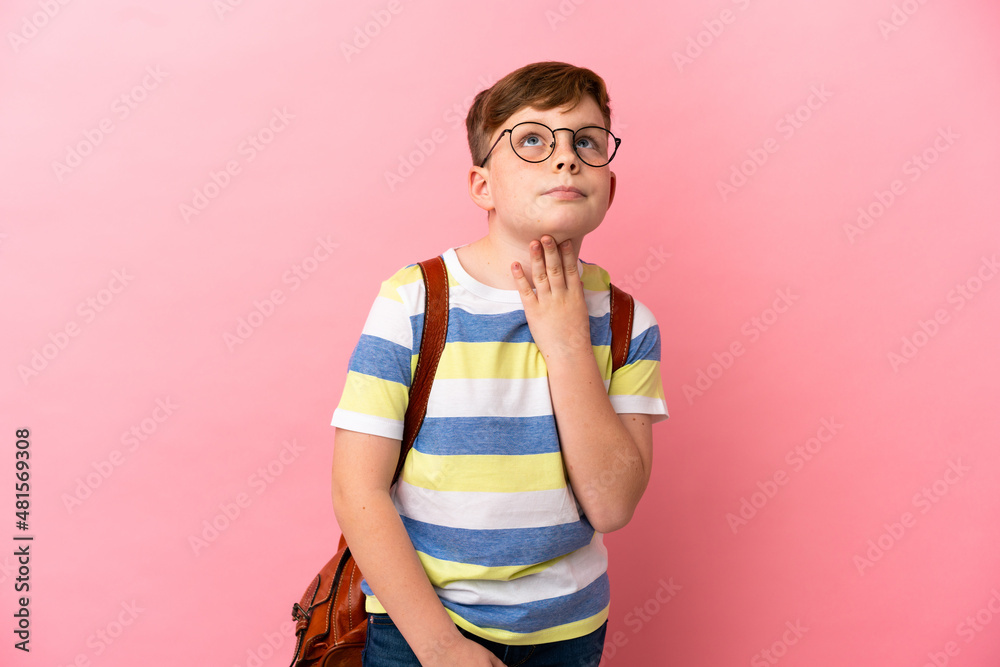 Little redhead caucasian boy isolated on pink background looking up while smiling Little redhead caucasian boy isolated on pink background looking up while smiling