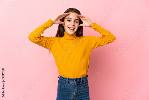 Little girl isolated on pink background with surprise expression