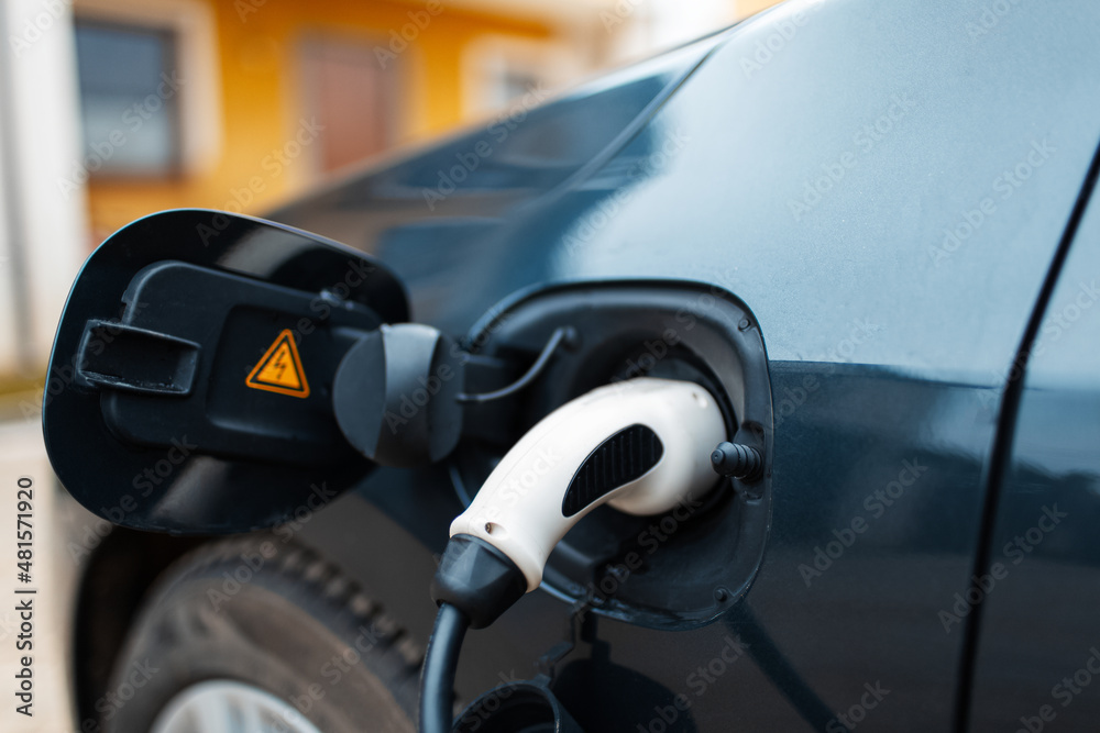Close-up of plug-in electric car on charging station. Alternative fuel. Close-up of plug-in electric car on charging station. Alternative fuel.