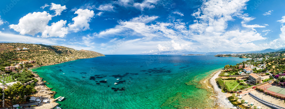 Panoramic blue lagoon, clear waters of Mediterranean sea, romantic island with peaceful sandy beach, bird eye panorama of coastal bay, beautiful seascape, amazing sky with clouds. Selective focus