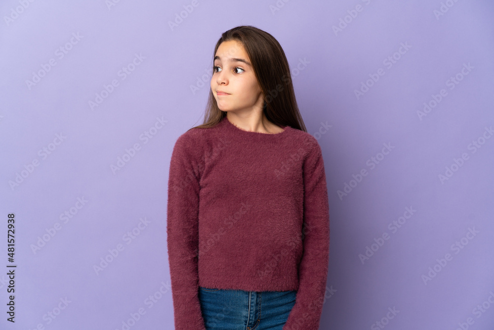 Little girl isolated on purple background making doubts gesture looking side