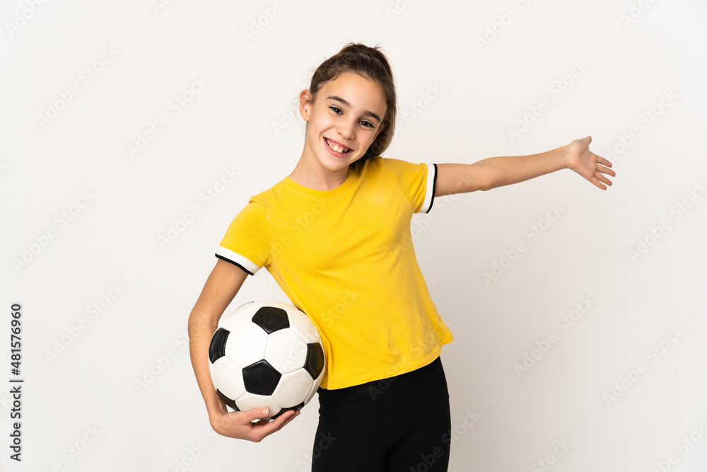 Little football player girl isolated on white background extending hands to the side for inviting to come