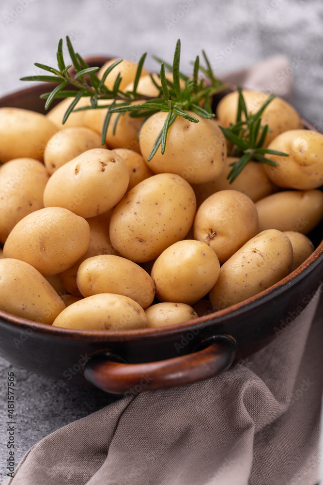 Raw small potatoes in a cast iron skillet on a beton background. Raw small potatoes in a cast iron skillet on a beton background.