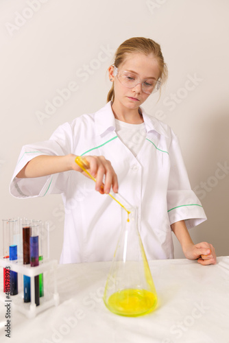a white girl in a white coat does a chemical experiment