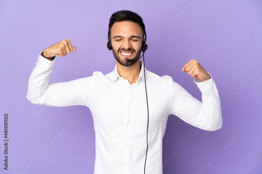 Naklejka premium Telemarketer man working with a headset isolated on purple background doing strong gesture