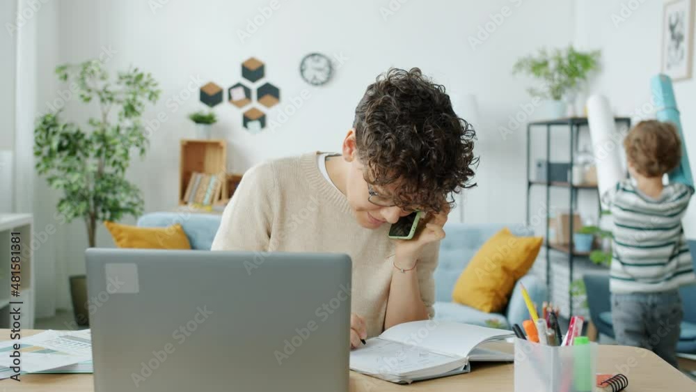 Slow motion of young mother businesswoman talking on mobile phone while naughty son running and screaming at home. People and family life concept. Slow motion of young mother businesswoman talking on mobile phone while naughty son running and screaming at home. People and family life concept.
