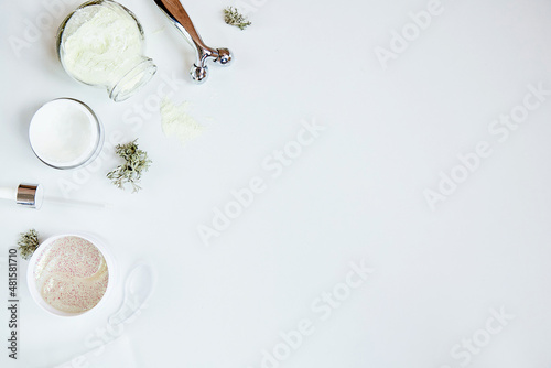 Face care cosmetics. Massager, alginate mask, patches. Scinimalism, polytasking functions concept. Dermatology multiuse cosmetics, multitasking beauty. Natural eco forest moss decorations . Copy space photo