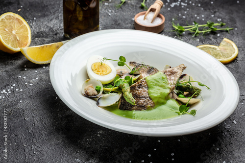 Fish dish - fried fish fillet of zander served with mussels, peas, asparagus and vegetable cream sauce. Restaurant menu, dieting, cookbook recipe