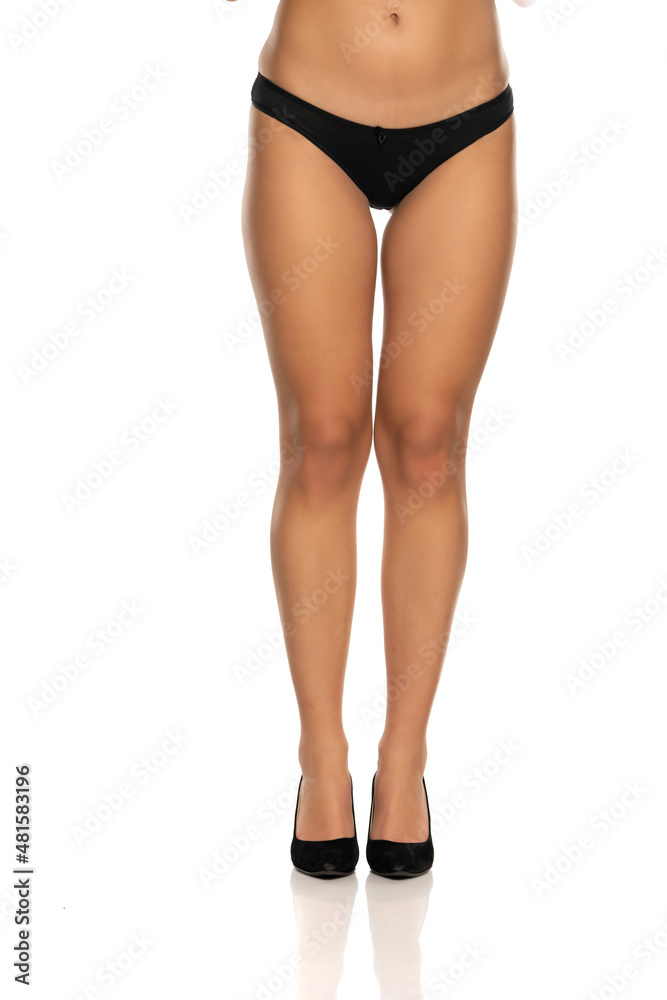 handsome female legs in black panties and shoes on a white handsome female legs in black panties and shoes on a white