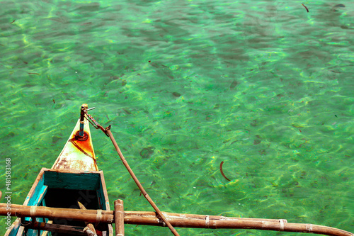 High angle view of the tip of a bangka or traditional wooden boat from the Philippines against the clear sea water off the coast of Camiguin Island
