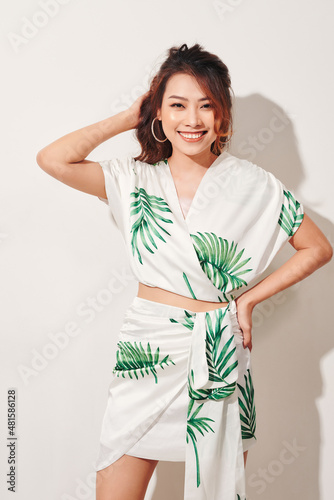 Beautiful young woman in tropical print green and white dress photo