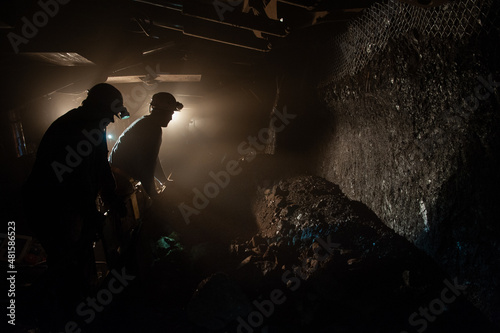 Underground coal mine shaft tunnel drift with miner and light.