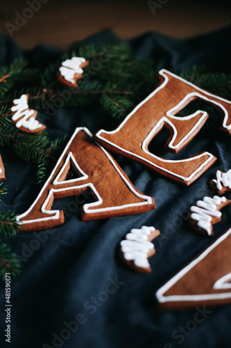 Weihnachten backen. Ein dunkles Flatlay mit Buchstaben Geschenke aus Lebkuchen mit Zuckerguss