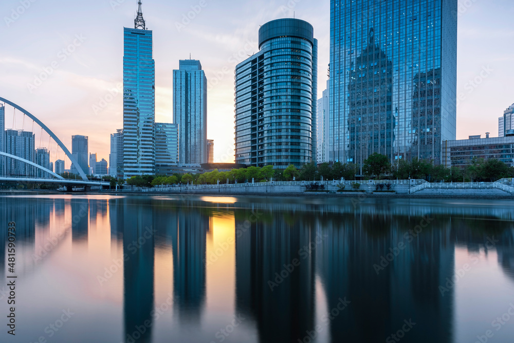 Obraz premium In the evening, the city skyscrapers are reflected on the water, and the picture is very beautiful