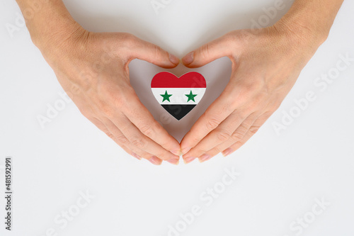 The national flag of Syria in female hands. The concept of patriotism  respect and solidarity with the citizens of Syria.