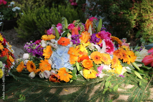 Fototapeta Naklejka Na Ścianę i Meble -  Bunte Blumen nach Beerdigung auf dem Friedhof