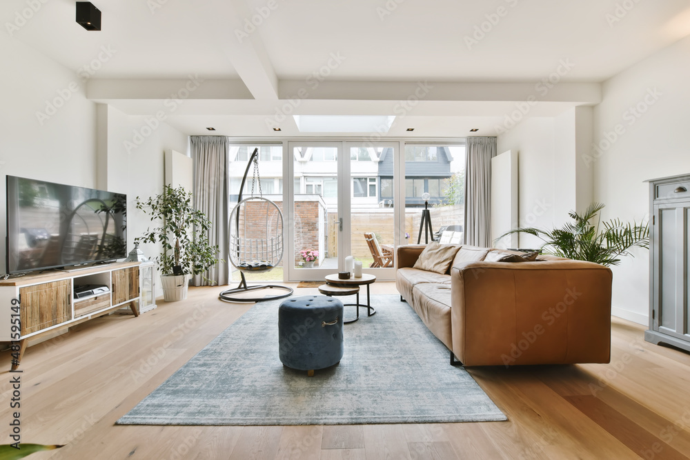 A lovely living room with a brown sofa and white ones with hanging swings - obrazy, fototapety, plakaty 