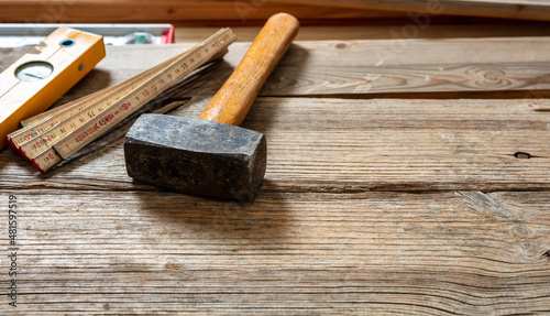 Sledge hammer old used on wooden table, space. Construction industry work bench.