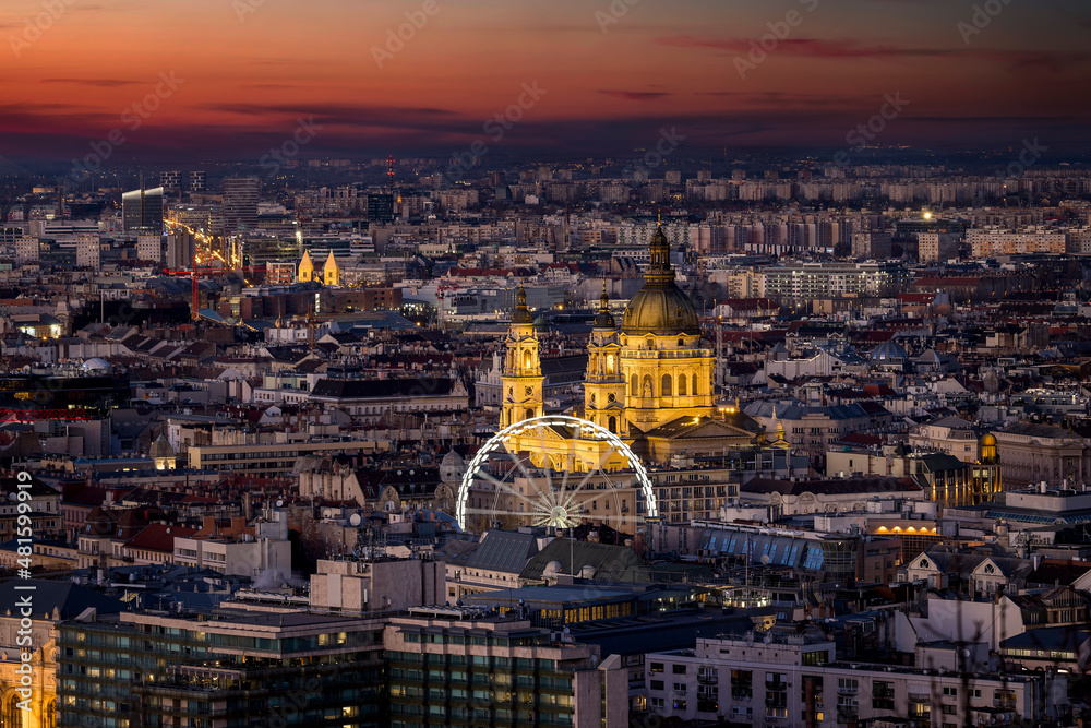 Elevated view of the illuminated urban skyline of Budapest, Hungary, with the famous St. Stephen's Basilica during dusk