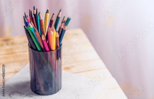 Colorful pencils in a plastic cup.
