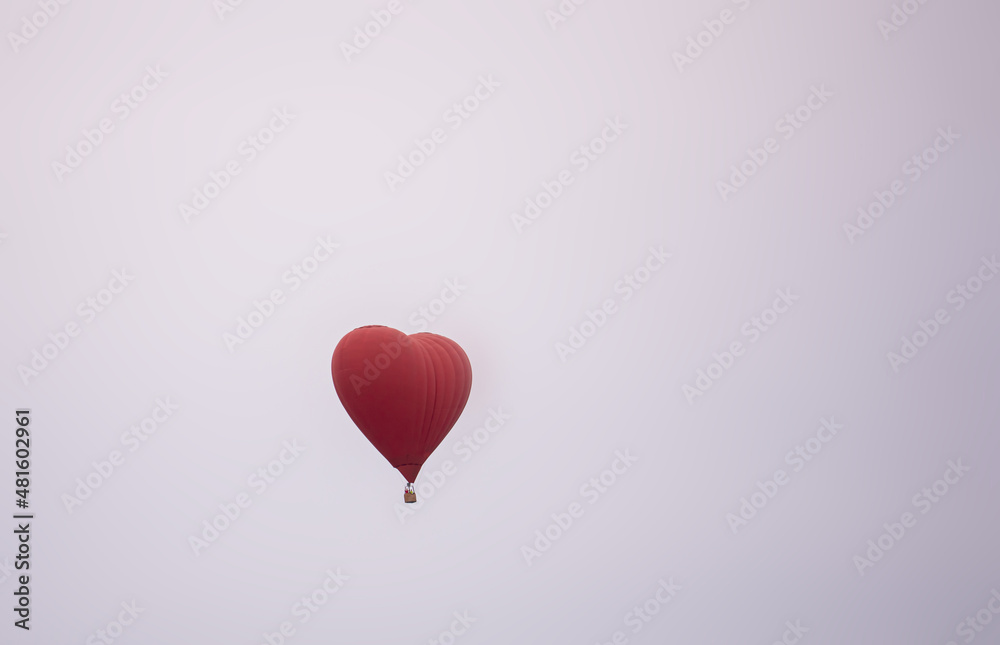a balloon with a basket is flying high in the sky