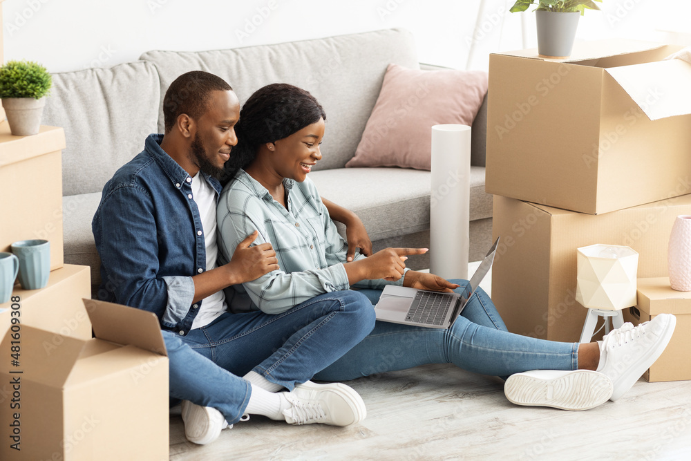 Online Order. Young black couple using laptop, purchasing furniture in internet Online Order. Young black couple using laptop, purchasing furniture in internet