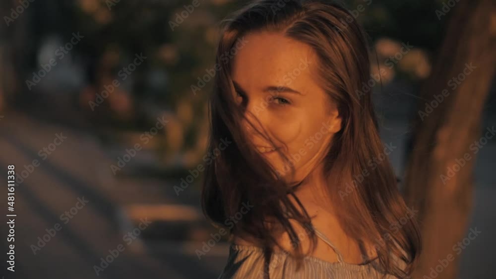 beautiful girl walks down the street, turns around and smiles beautiful girl walks down the street, turns around and smiles