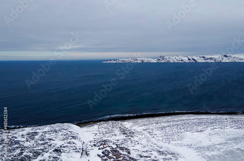 Winter landscape with mountains and snow in a polar day, Arctic Ocean, the Barents Sea, settlement of Teriberka, Russia. aerial top view