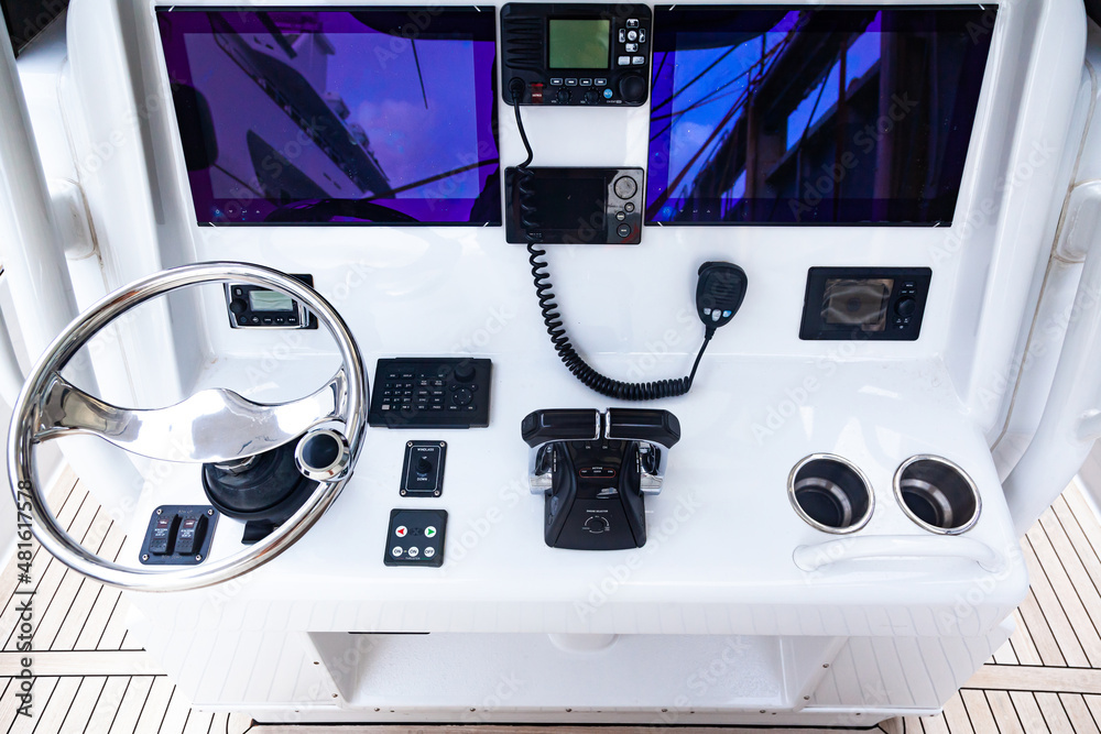 Luxury yacht control panel with steering wheel, gear levers, navigation ...